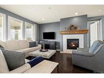 Bright living room features a fireplace and comfortable seating at 7800 E 148Th Dr, Thornton, CO 80602