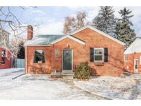 Charming brick home featuring a quaint arched window, front yard, and classic architectural details at 1117 Jersey St, Denver, CO 80220