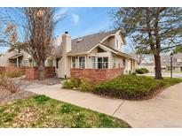Charming townhome with manicured landscaping, brick accents, and a private patio at 5317 W Iliff Dr # 101, Lakewood, CO 80227