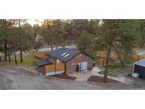 Charming brick home with a well-maintained yard, updated fence and stone patio surrounded by mature trees at 34480 County Road 17, Elizabeth, CO 80107
