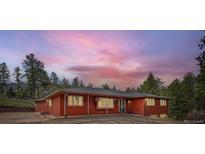 Inviting single-story home featuring a warm red exterior and large windows perfect for enjoying scenic views at 4776 Red Rock Dr, Larkspur, CO 80118