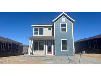 Charming two-story home with a colorful front door and a well-maintained, gravel front yard at 2303 Peregrine Dr, Brighton, CO 80601