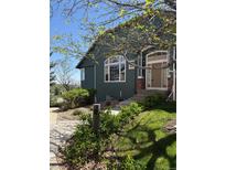 Inviting home exterior with beautiful landscaping, stone walkway, and well-maintained lawn at 2855 Rock Creek Cir # 129, Superior, CO 80027