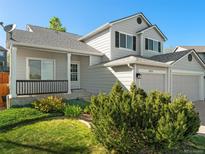 Charming home featuring a well-manicured front yard and a welcoming covered porch at 16212 Blueleaf Pl, Parker, CO 80134