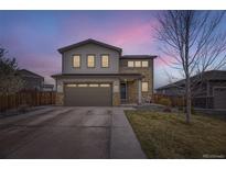 Charming two-story home with a manicured lawn, stone accents, and an attached two-car garage at 22255 E Mansfield Pl, Aurora, CO 80018