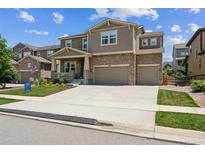 Charming two-story home featuring a stone and siding exterior, attached two-car garage, and manicured front yard at 887 Sundance Ln, Erie, CO 80516