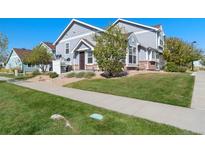 Charming two-story home with a well-manicured lawn, complemented by gravel landscaping and mature trees at 19046 E 57Th Pl # A, Denver, CO 80249