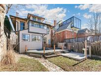 Spacious backyard with deck, patio, and mature trees, great for outdoor entertaining at 1451 N Gilpin St, Denver, CO 80218