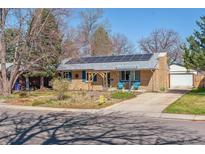 Charming brick home featuring solar panels, a landscaped front yard, and a welcoming pergola at 1744 S Leyden St, Denver, CO 80224