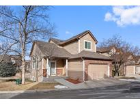 Tan two-story home with attached garage and landscaping at 6817 S Webster St # C, Littleton, CO 80128