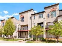Modern townhome exteriors with balconies and patios, complemented by young trees and well-maintained landscaping at 8953 E Northfield Blvd, Denver, CO 80238