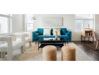 Bright living room boasts stylish furnishings, a plush blue sofa, and neutral decor at 8953 E Northfield Blvd, Denver, CO 80238