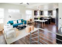 Bright and airy living room seamlessly flows into the modern kitchen area at 8953 E Northfield Blvd, Denver, CO 80238