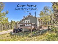 Cozy two-story home featuring a charming deck and a lush, natural setting in a mountain area at 32252 Steven Way, Conifer, CO 80433