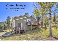 Charming home featuring a welcoming entrance, wooden deck, and scenic natural surroundings at 32252 Steven Way, Conifer, CO 80433