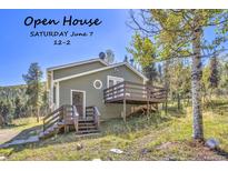 Charming home exterior with deck, surrounded by trees, perfect for mountain living. Open house June 7! at 32252 Steven Way, Conifer, CO 80433