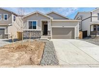 Charming single-Gathering home with a two-car garage and modern stone accents at 9712 Cathay St, Commerce City, CO 80022