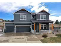 Charming two-story home featuring a welcoming front porch, and a three car garage at 795 Woodmoor Acres Dr, Monument, CO 80132