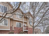 Charming townhome featuring wood siding, brick accents, and a cozy front porch at 6847 S Webster St # A, Littleton, CO 80128