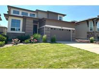 Charming home exterior with manicured lawn, and a two-car garage in a suburban neighborhood at 9482 Kendrick Way, Arvada, CO 80007