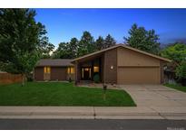 Charming single-Gathering home featuring a brick facade, manicured lawn, and attached two-car garage at 1843 S Pierson Ct, Lakewood, CO 80232
