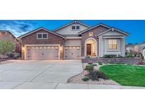 Beautiful front exterior with stone accents, three-car garage, concrete driveway and well-maintained lawn at 3242 Waterfront Dr, Monument, CO 80132