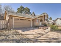 Tan house featuring a two-car garage with a driveway and well-kept landscaping at 21470 E Aberdeen Dr, Centennial, CO 80015
