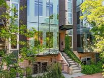 Contemporary home featuring a brick facade, expansive glass windows and verdant greenery at 2565 Champa St, Denver, CO 80205