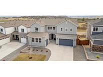 Beautiful two-story home with a gray exterior, well-maintained landscaping, and a two-car garage at 174 Rockingham Cir, Castle Pines, CO 80108