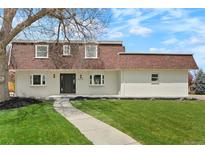 Charming two-story home with a landscaped yard, featuring a well-maintained lawn and walkway at 6325 W Portland Pl, Littleton, CO 80128