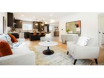 Open-concept living room with modern decor, including a stylish kitchen island and comfortable seating at 6325 W Portland Pl, Littleton, CO 80128