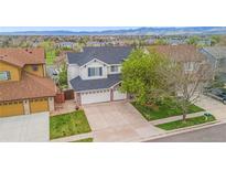 Traditional two-story home featuring a large driveway and well-maintained lawn and landscaping at 6614 W Gould Dr, Littleton, CO 80123