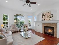Bright living room boasts a fireplace, large windows, and a ceiling fan at 86 Woodland Cir, Highlands Ranch, CO 80126