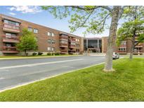 Brick condominium building featuring balconies, a glass entryway, and a well-maintained green lawn at 12565 Sheridan Blvd # 105, Broomfield, CO 80020