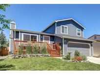 Charming home with a beautiful front yard, a wooden deck, and fresh exterior paint at 8463 Wheatgrass Cir, Parker, CO 80134