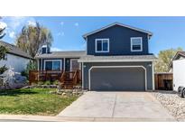 Two-story home boasts a two-car garage, manicured lawn, and a charming deck, perfect for enjoying the outdoors at 8463 Wheatgrass Cir, Parker, CO 80134