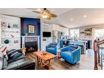 Cozy living room featuring a fireplace, plush armchairs, and an open kitchen concept at 8463 Wheatgrass Cir, Parker, CO 80134
