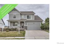 Charming two-story home featuring a well-manicured lawn, stone accents, and an attached two-car garage at 8695 Torrey St, Arvada, CO 80007
