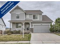 Charming two-story home features a covered porch, well-maintained landscaping, and an attached two-car garage at 8695 Torrey St, Arvada, CO 80007