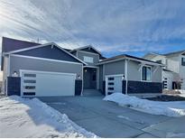 Gray two-story house with white garage doors and snowy driveway at 42978 Colonial Trl, Elizabeth, CO 80107