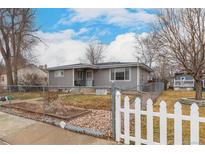 Charming single-story home featuring a fenced yard, mature trees, and a cozy front porch at 117 6Th St, Frederick, CO 80530