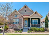Charming single Gathering home with stone accents, inviting front porch, and well-maintained landscaping at 8272 E 55Th Pl, Denver, CO 80238