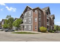 Attractive building with red brick and grey siding, manicured lawn and parking area visible at 14353 E 1St Dr # 302, Aurora, CO 80011