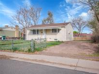 Quaint single-story home featuring a partially fenced yard and off-street parking at 7881 Kenwood St, Commerce City, CO 80022