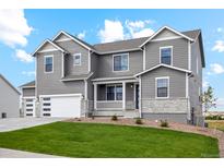 Beautiful two-story home featuring gray siding, stone accents, and a well-manicured front lawn at 42968 Colonial Trl, Elizabeth, CO 80107