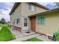 Charming townhome featuring a welcoming front entrance, complemented by a well-maintained lawn and landscape at 3355 S Flower St # 166, Lakewood, CO 80227