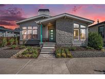 Charming gray home with stone accents, well-manicured landscaping, and inviting green front door at 10179 E 59Th North Pl, Denver, CO 80238