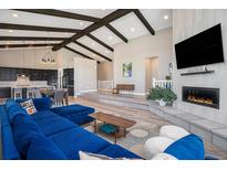Spacious living room featuring vaulted ceilings, wood floors, and a modern fireplace at 10179 E 59Th North Pl, Denver, CO 80238