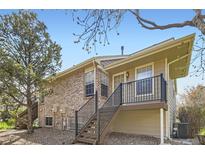 Multi-level exterior elevation with brick, siding, and iron railing detail at 1470 S Quebec Way # 244, Denver, CO 80231