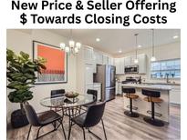 Modern kitchen features stainless steel appliances, granite countertops, and a dining area with stylish lighting at 12920 Jasmine St # F, Thornton, CO 80602